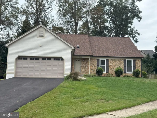 a view of a house with a yard and potted plants