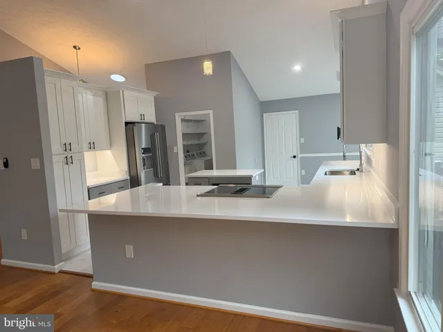 a kitchen with stainless steel appliances a sink a refrigerator and a refrigerator