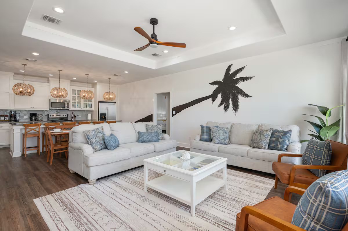a living room with furniture kitchen view and a potted plant
