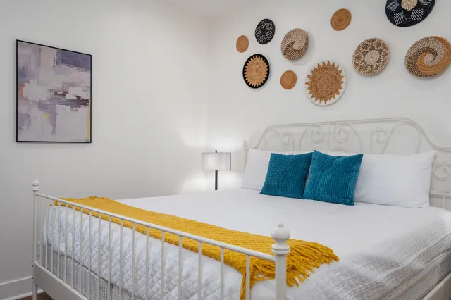 a bedroom with a bed and painting on the wall