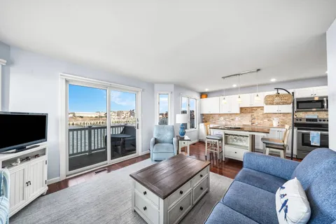 a living room with stainless steel appliances furniture and a table