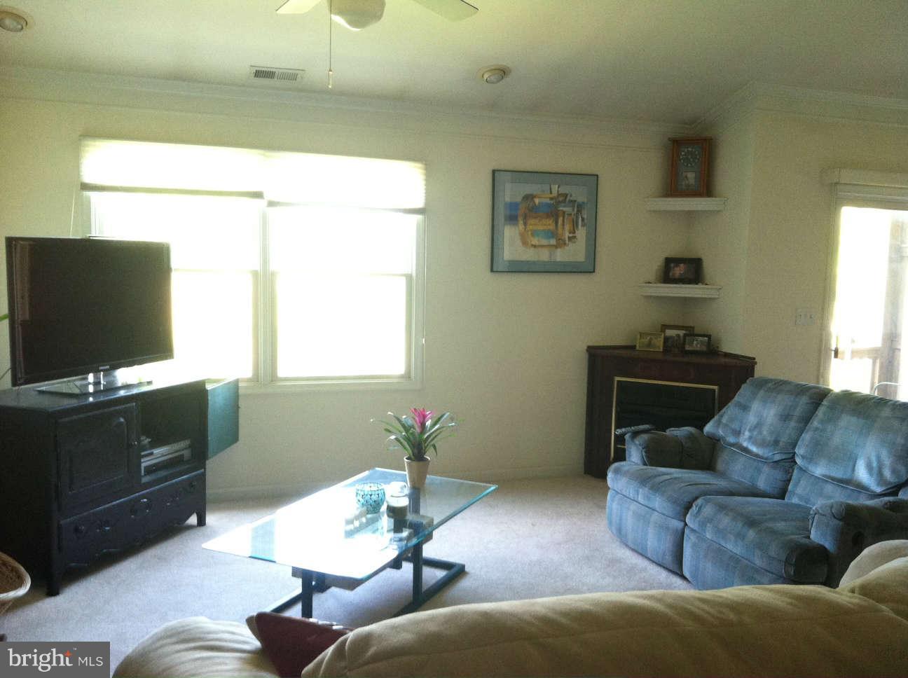 413 Merganser Court, Unit G Chester, MD 21619 - Photo 10 of 12 a living room with furniture and a flat screen tv