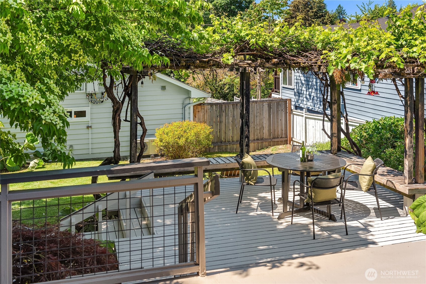 5648 38th Avenue Southwest Seattle, WA 98126 - Photo 21 of 40 a view of a patio with table and chairs and wooden fence
