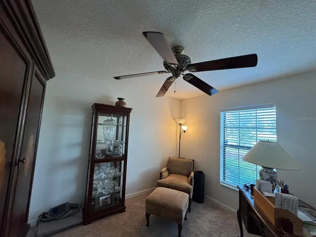 a living room with furniture a ceiling fan and a window