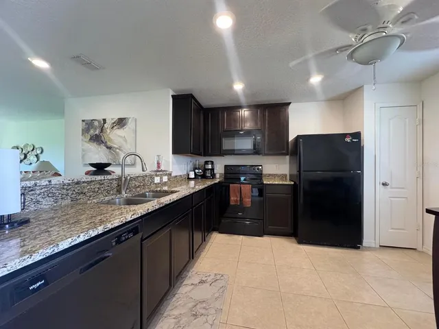 a kitchen with a sink refrigerator and cabinets