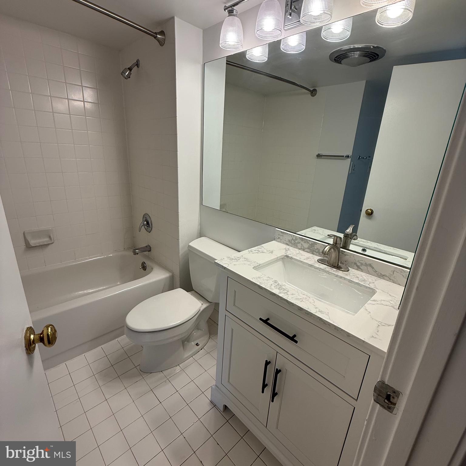 2111 Wisconsin Avenue Northwest, Unit 402 Washington, DC 20007 - Photo 15 of 22 a bathroom with a sink a toilet a mirror a bathtub and shower