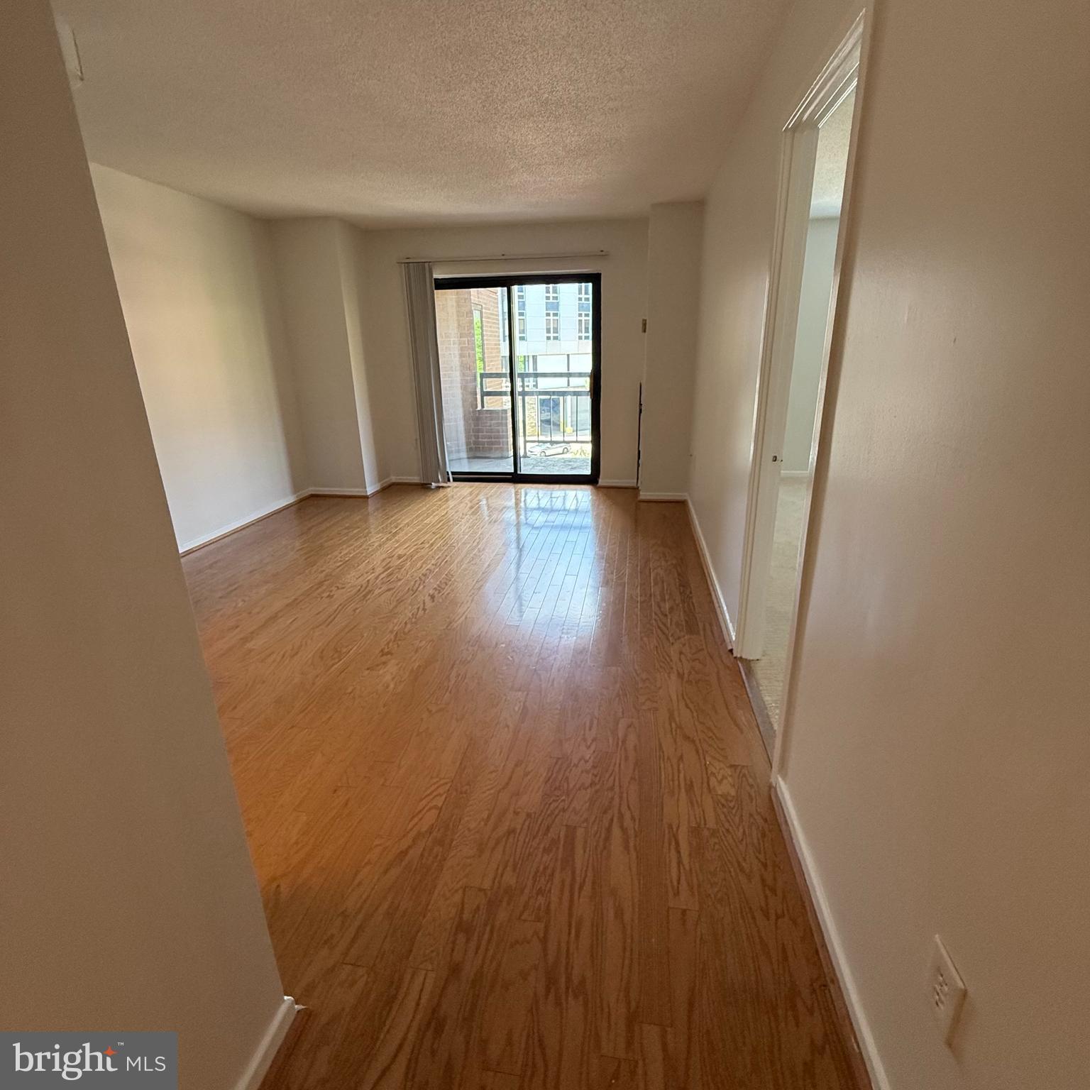 2111 Wisconsin Avenue Northwest, Unit 402 Washington, DC 20007 - Photo 4 of 22 wooden floor in an empty room with a window