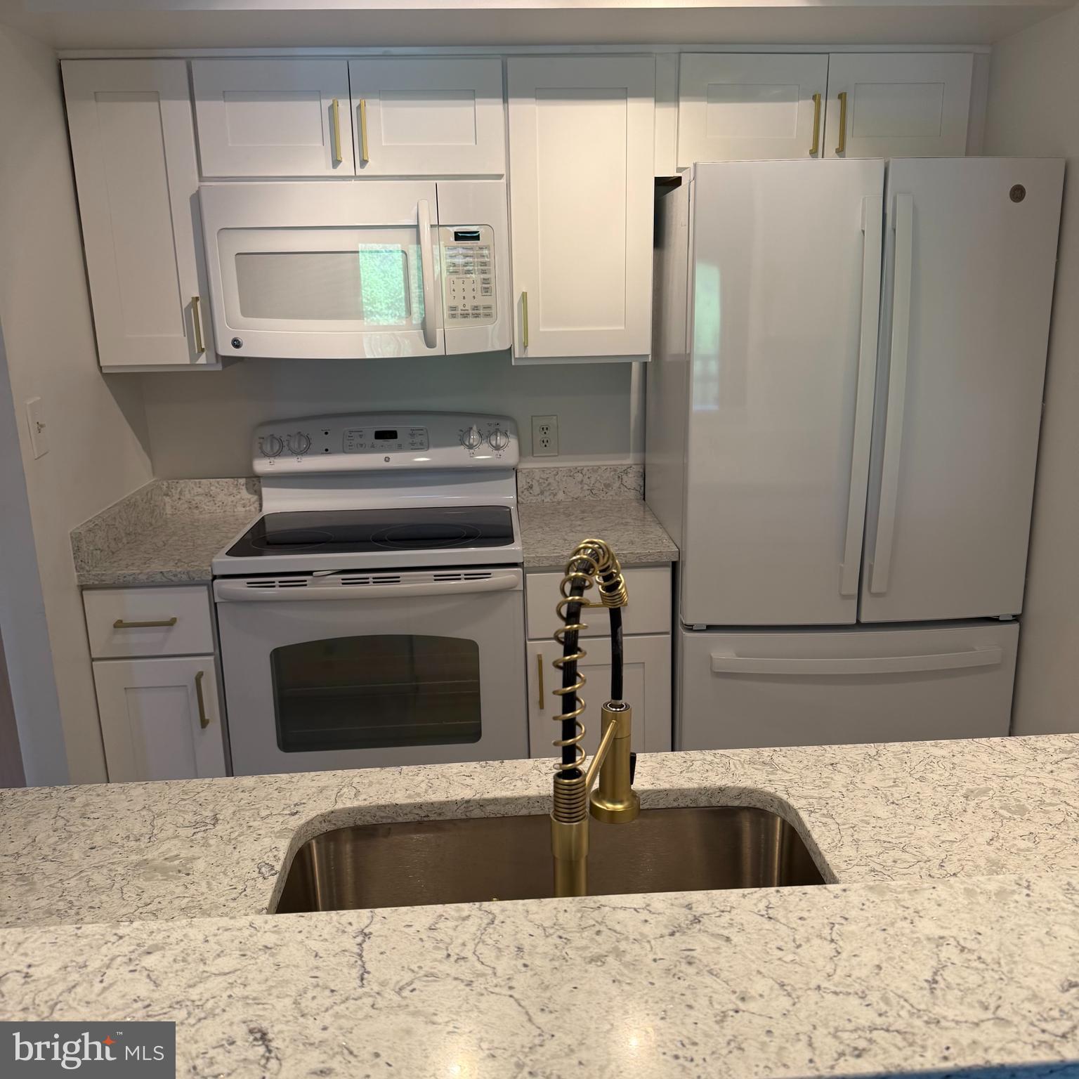 2111 Wisconsin Avenue Northwest, Unit 402 Washington, DC 20007 - Photo 9 of 22 a kitchen with granite countertop a refrigerator sink and stove