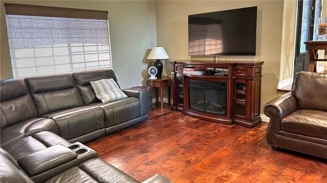 a living room with furniture a flat screen tv and a fireplace