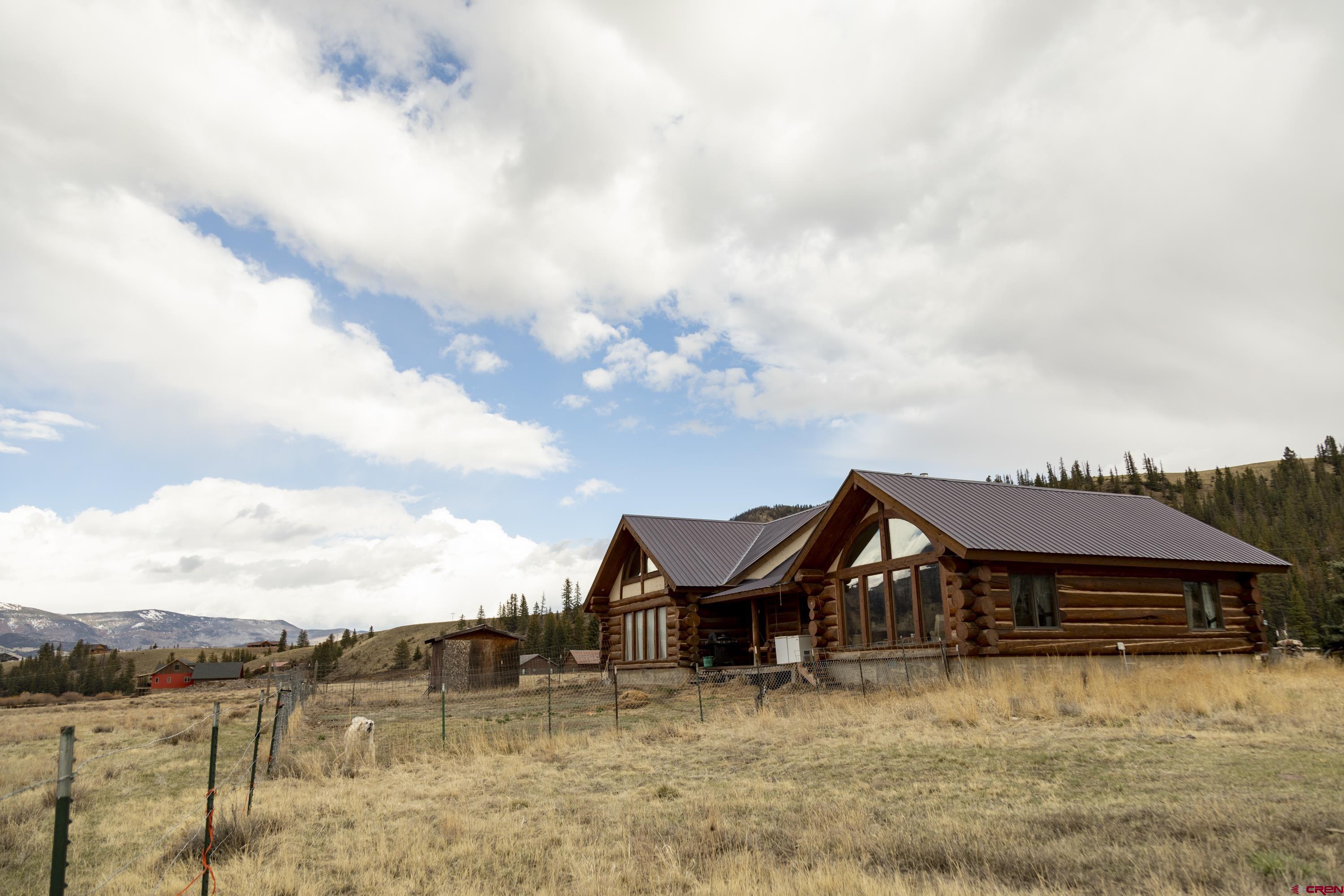 a view of a big house with a big yard and large trees