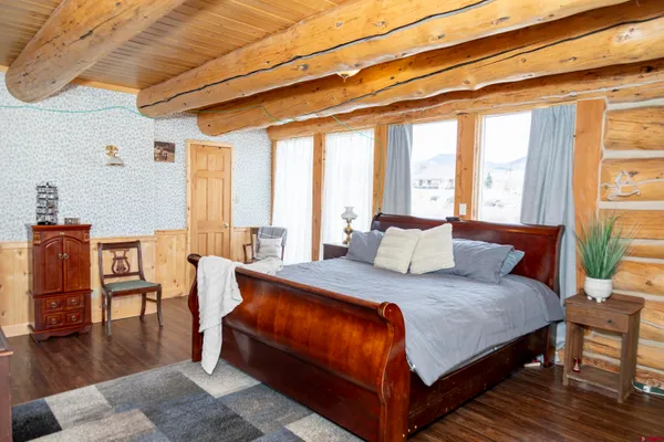 a large bedroom with a bed and wooden floor