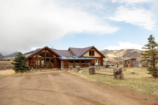 a view of a big house with a fountain and yard