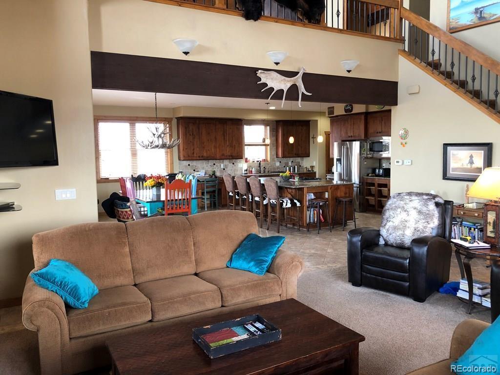 9780 Canyon Point Drive Rye, CO 81069 - Photo 28 of 35 a living room with furniture kitchen view and a flat screen tv
