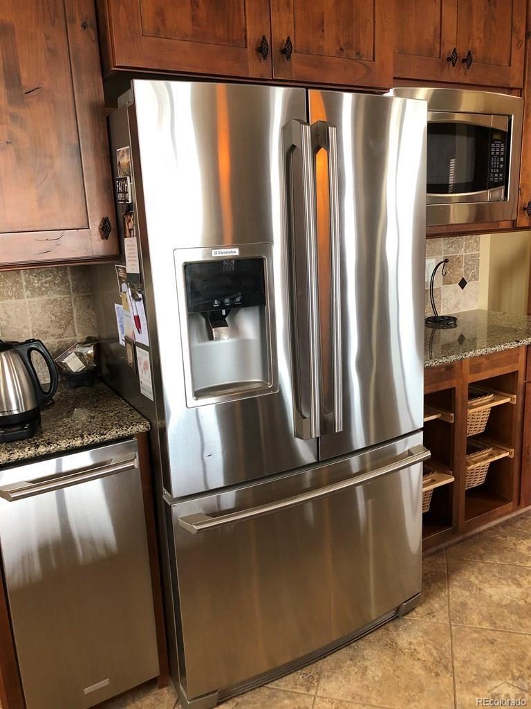 9780 Canyon Point Drive Rye, CO 81069 - Photo 30 of 35 a metallic refrigerator freezer sitting inside of a kitchen