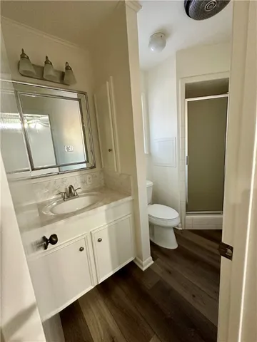 a view of empty room with a fireplace and wooden floor