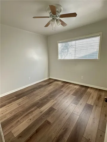 a view of a room with wooden floor and ceiling fan