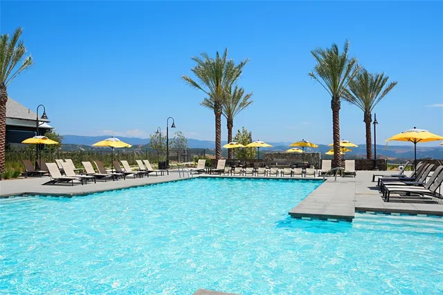 a view of a patio with a table chairs and a swimming pool