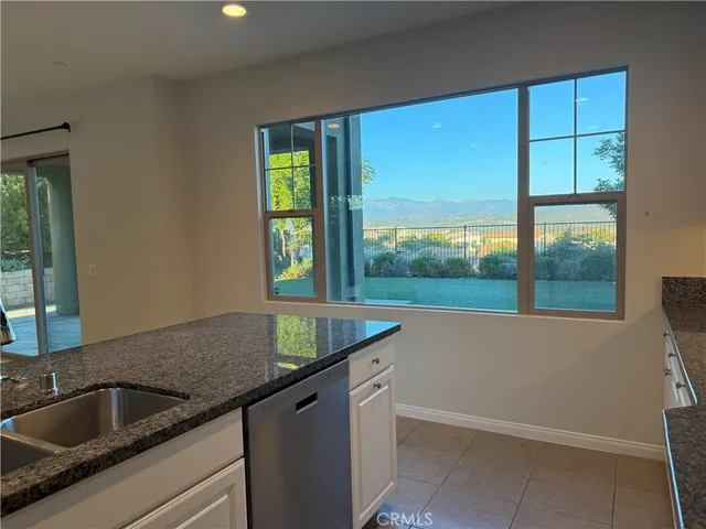 a kitchen with a sink dishwasher and cabinets with wooden floor