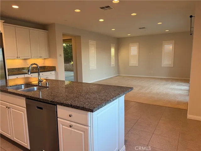 a bathroom with a granite countertop toilet and a sink