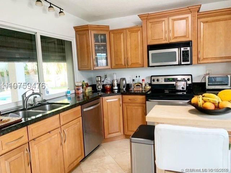 261 Northwest 11th Avenue Boca Raton, FL 33486 - Photo 11 of 14 a kitchen with granite countertop a sink and a stove top oven