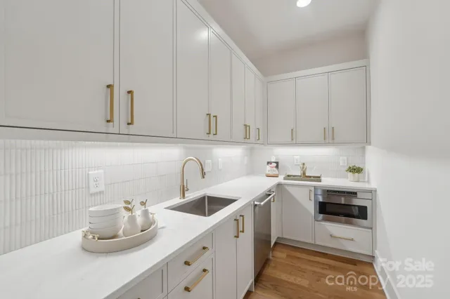 a kitchen with stainless steel appliances granite countertop a sink dishwasher a stove and cabinets