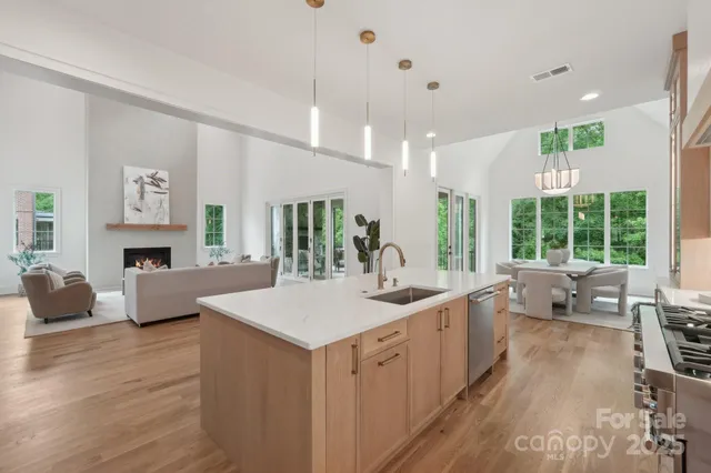 a large living room with stainless steel appliances kitchen island granite countertop furniture and a fireplace