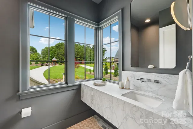 a bathroom with a bathtub a sink and a large window