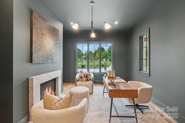 a living room with furniture a large window and a fireplace