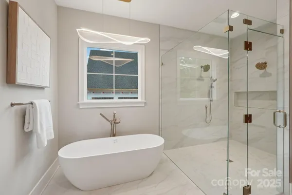 a white bath tub sitting next to a shower
