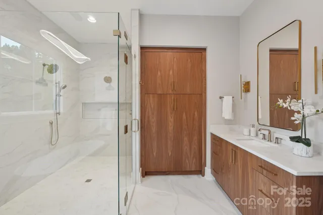 a bathroom with a double vanity sink mirror and shower