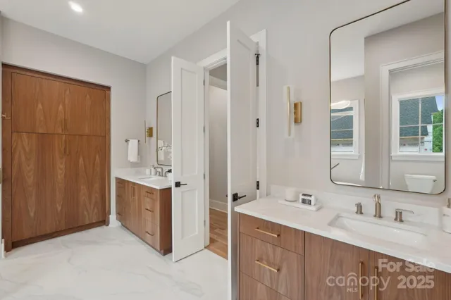 a spacious bathroom with a double vanity sink a mirror and a shower