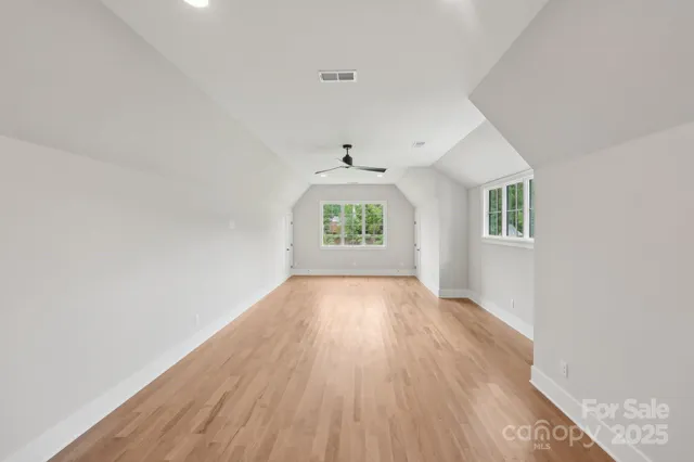 a view of empty room with windows and ceiling fan