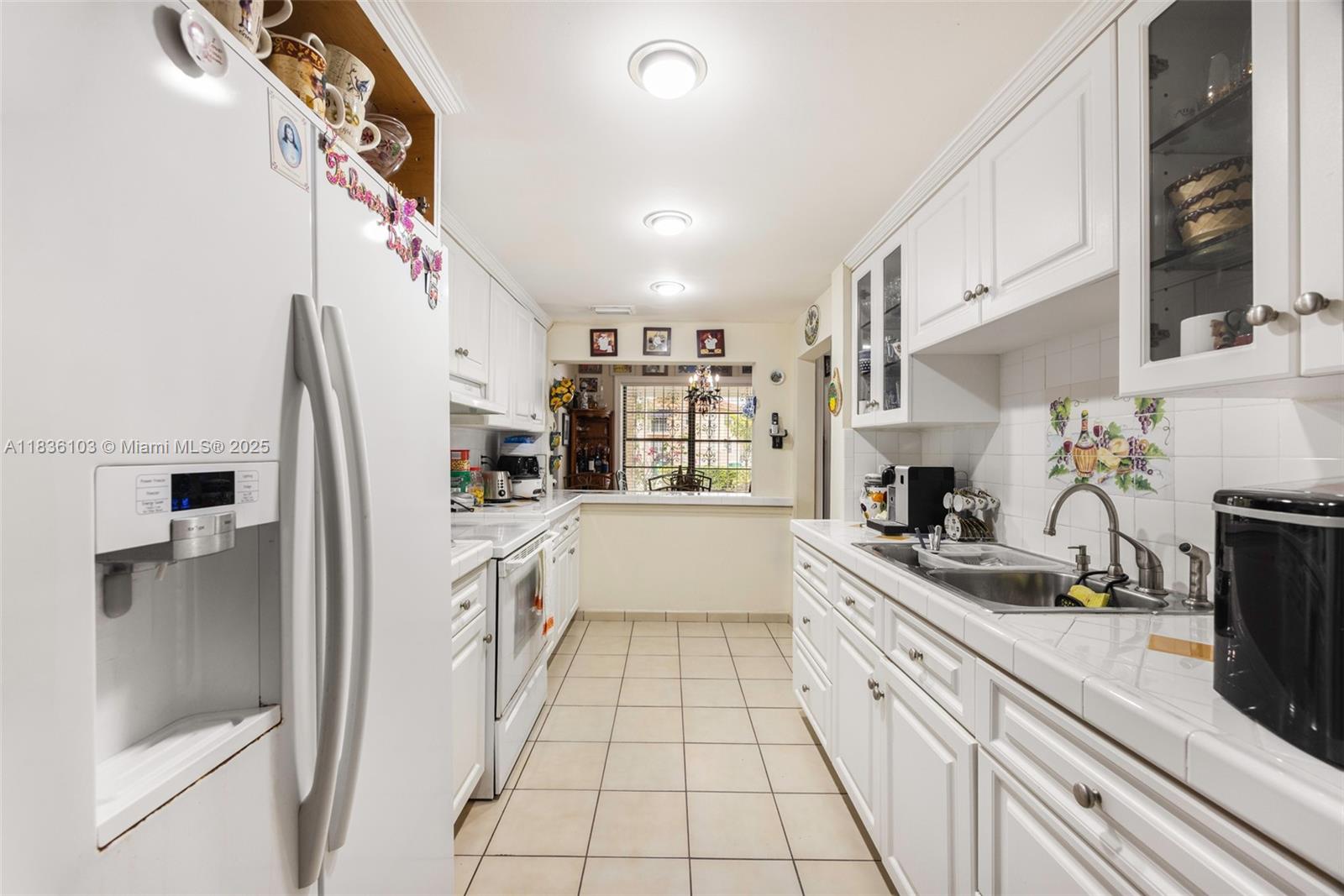 811 Southwest 25th Road Miami, FL 33129 - Photo 16 of 23 a large white kitchen with stainless steel appliances granite countertop a sink and cabinets
