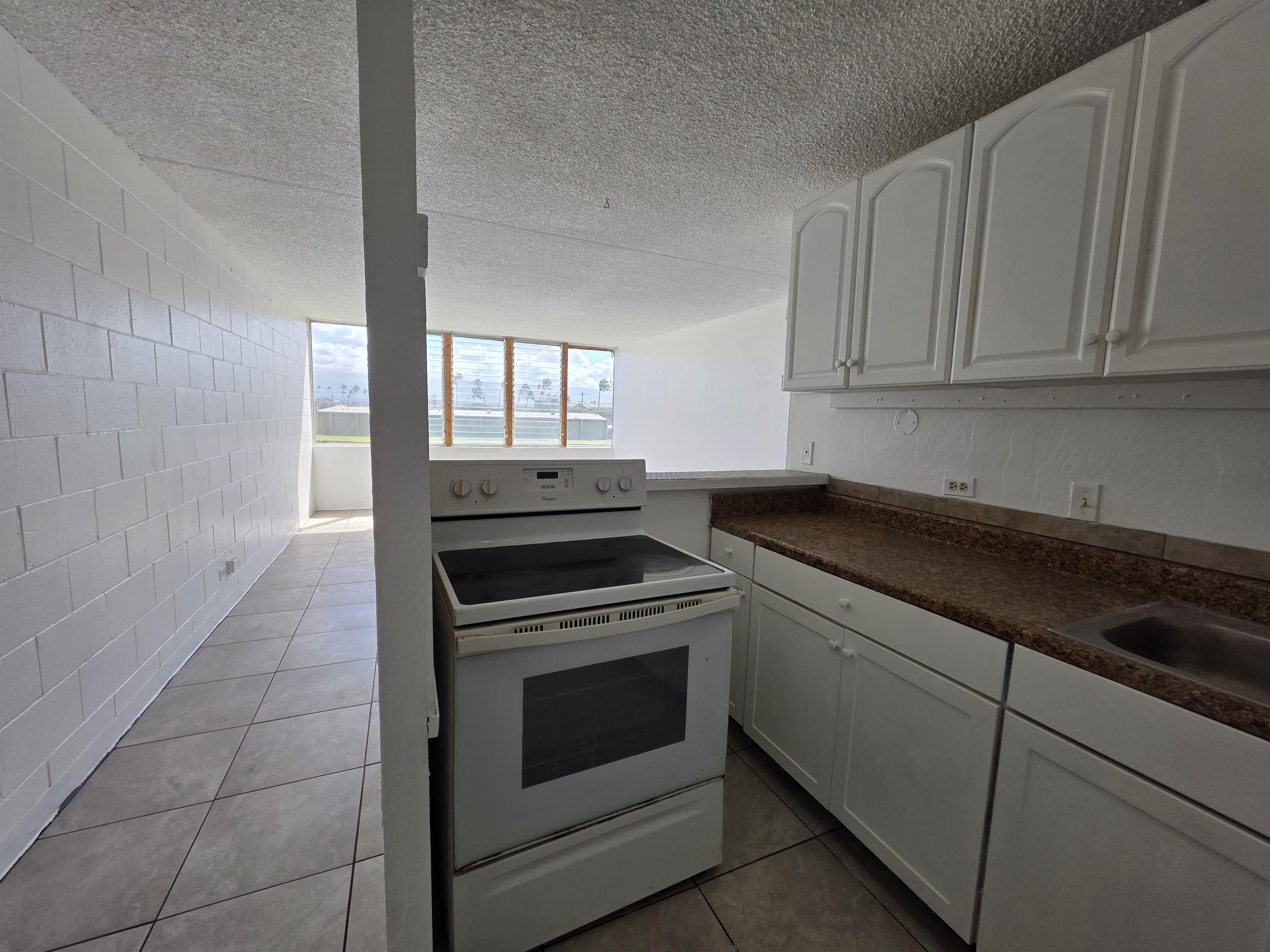 111 Kahului Beach Road, Unit B306 Kahului, HI 96732 - Photo 3 of 29 a kitchen with granite countertop white cabinets and white appliances