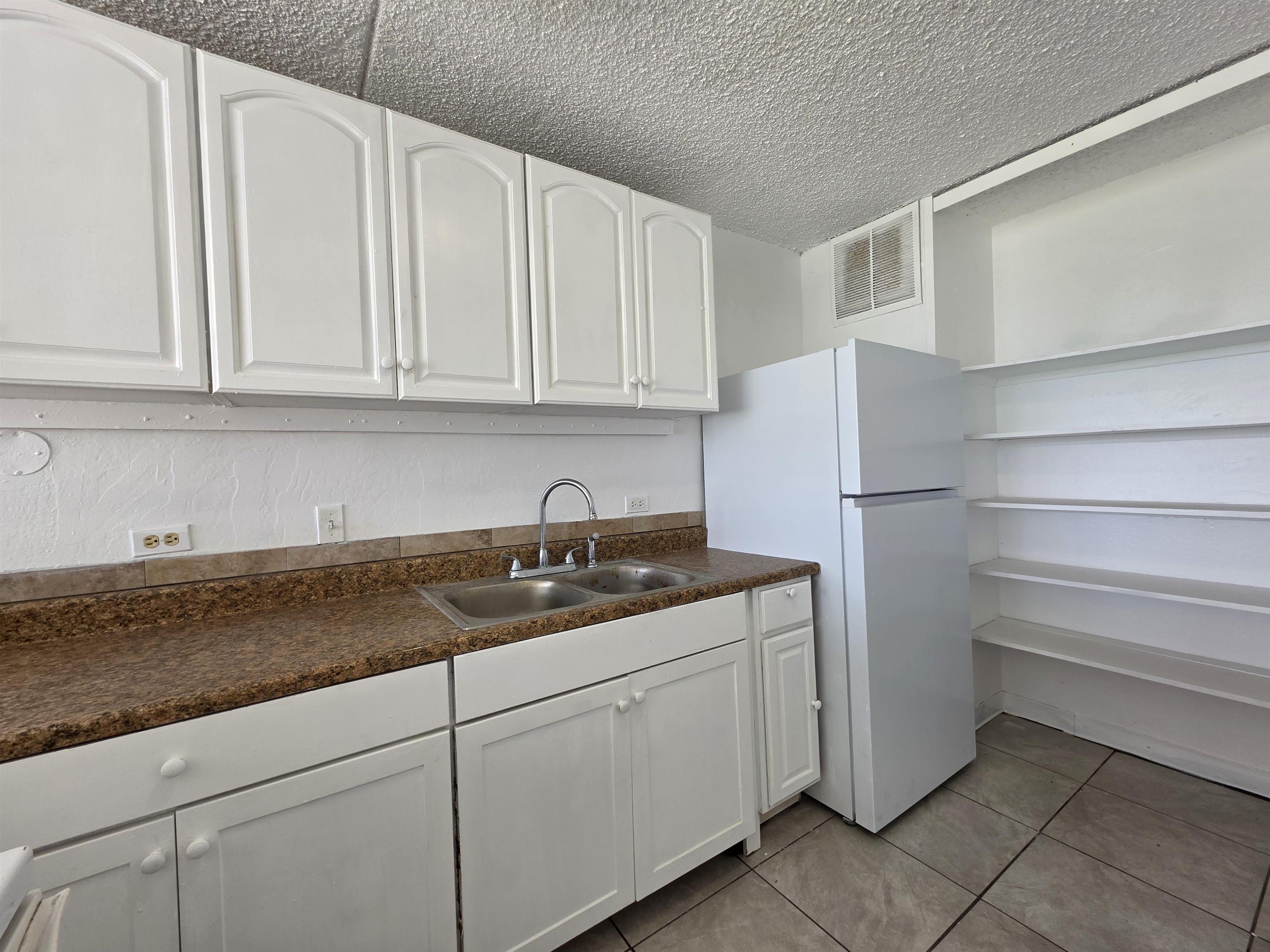 111 Kahului Beach Road, Unit B306 Kahului, HI 96732 - Photo 5 of 29 a kitchen with granite countertop cabinets and refrigerator