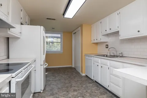 a kitchen with white cabinets and a stove