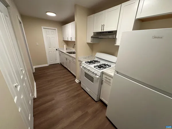 a kitchen with white cabinets and white appliances