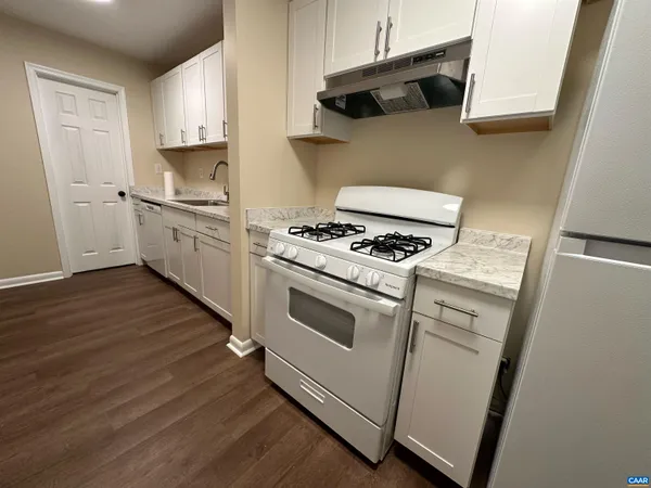 a kitchen with cabinets and wooden floor