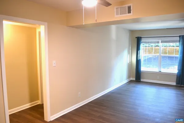 a view of an empty room with wooden floor