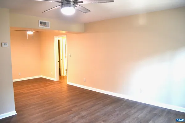 an empty room with wooden floor and a window
