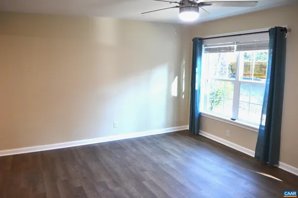 a view of an empty room with window and wooden floor