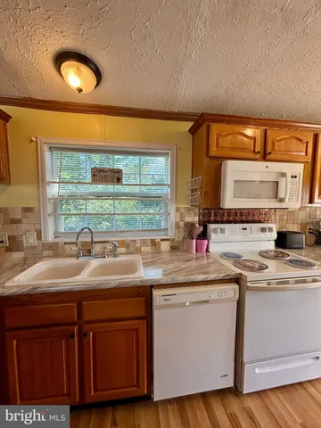 a kitchen with stainless steel appliances granite countertop a sink and a wooden cabinets