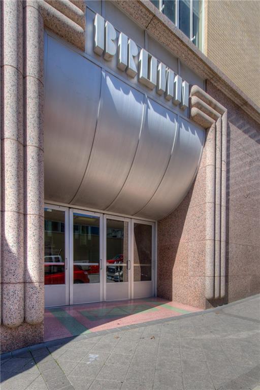 710 Colorado Street, Unit 6E Austin, TX 78701 - Photo 18 of 24 Discover this commercial entryway, featuring a prominent business sign and large glass doors.