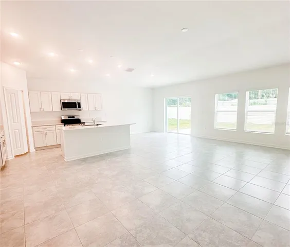 a view of a kitchen with a sink a stove top oven and cabinets