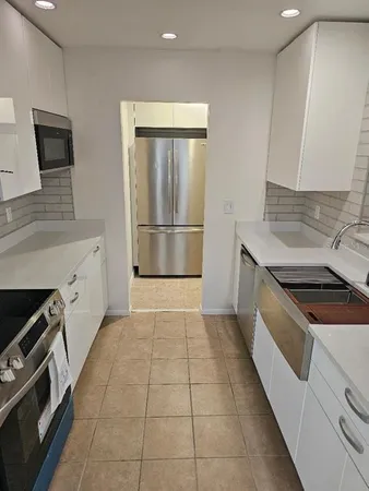 a kitchen with a stove a sink and a refrigerator