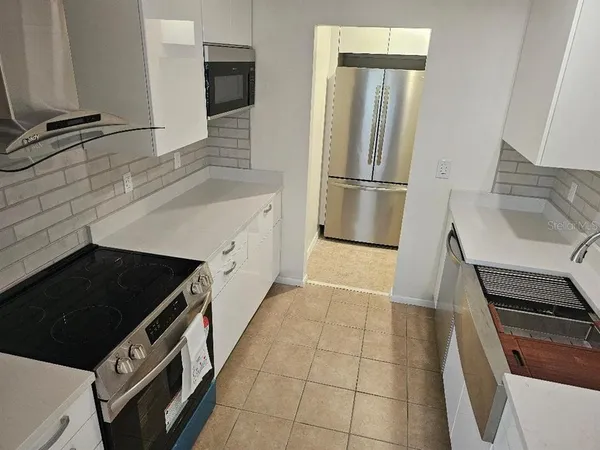 a kitchen with granite countertop a stove and a refrigerator