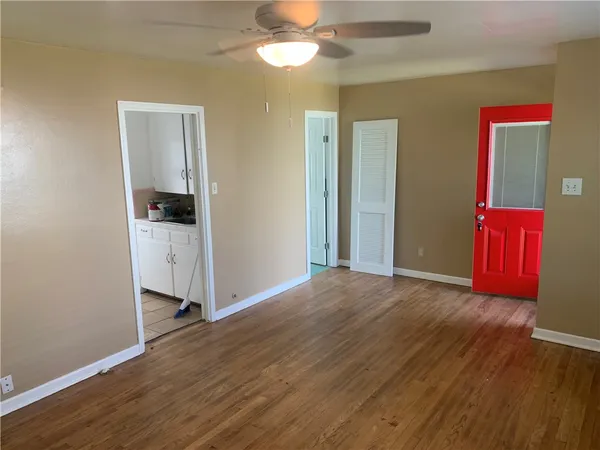a view of a room with wooden floor closet and a ceiling fan