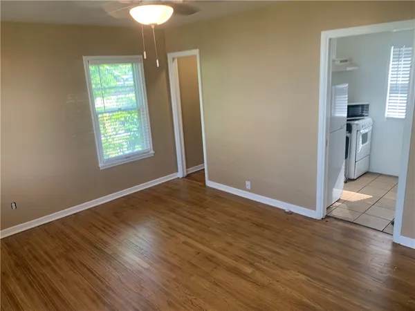 an empty room with wooden floor and windows