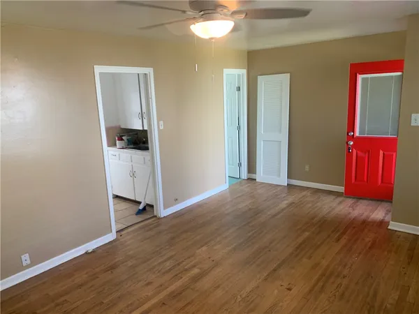 a view of hallway with window and wooden floor