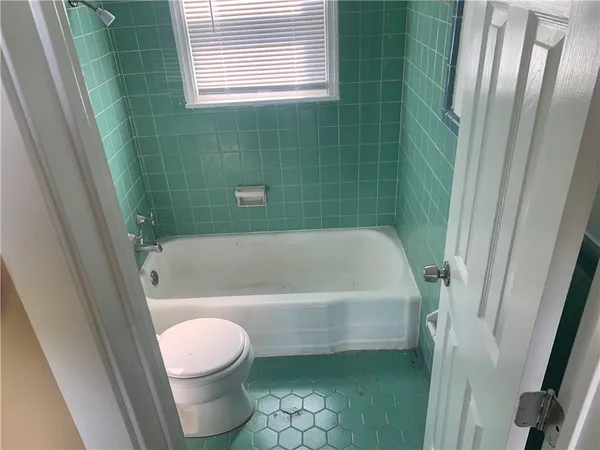 a bathroom with a tub a sink and toilet